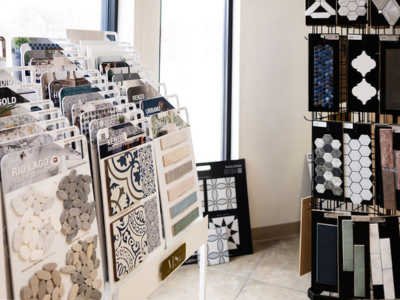 A display rack shows various tile samples, including mosaic, patterned, and stone tiles, in our local Columbia, MO flooring store.
